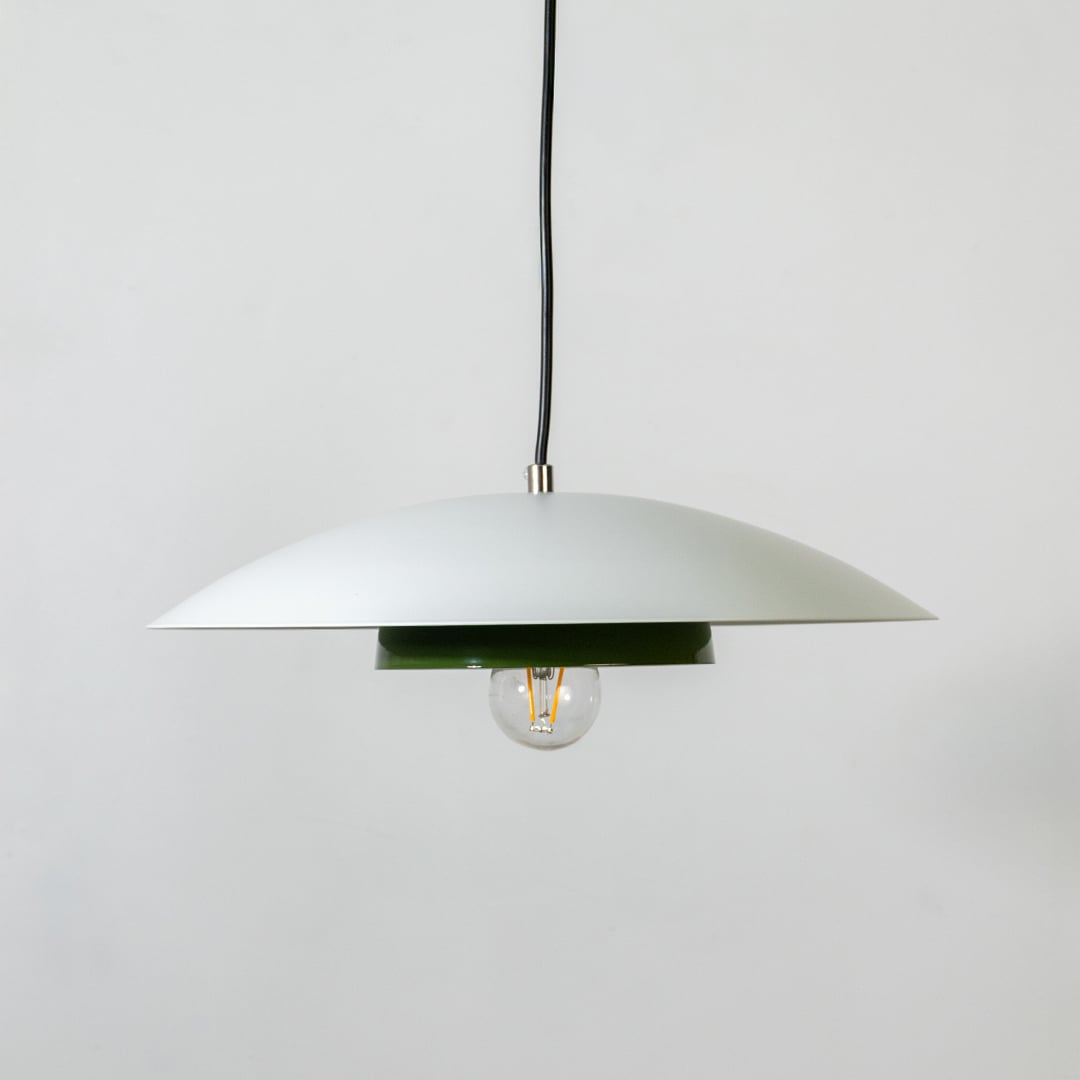 White metal pendant light with bulb off and green inner plate shown on white background for modern home interior decor.