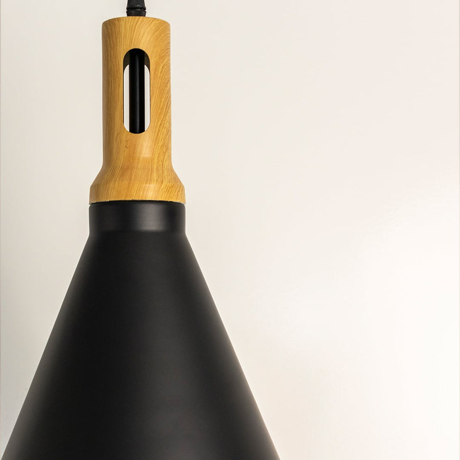 A detailed closeup of the black cone pendant lamp showing the wooden top and smooth matte finish highlighting its modern craftsmanship and clean design.