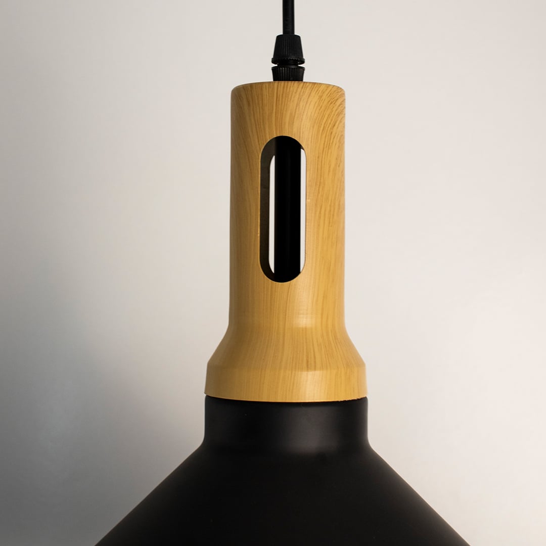 A closeup shot of a black wood pendant light focusing on the smooth matte shade and the natural wooden top with its carved slot and clean detailing.