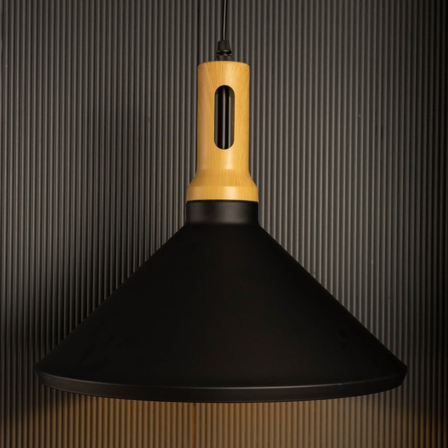 A black wood pendant light switched on against a black background where the warm light shines brightly and the wooden accent contrasts with the dark backdrop.