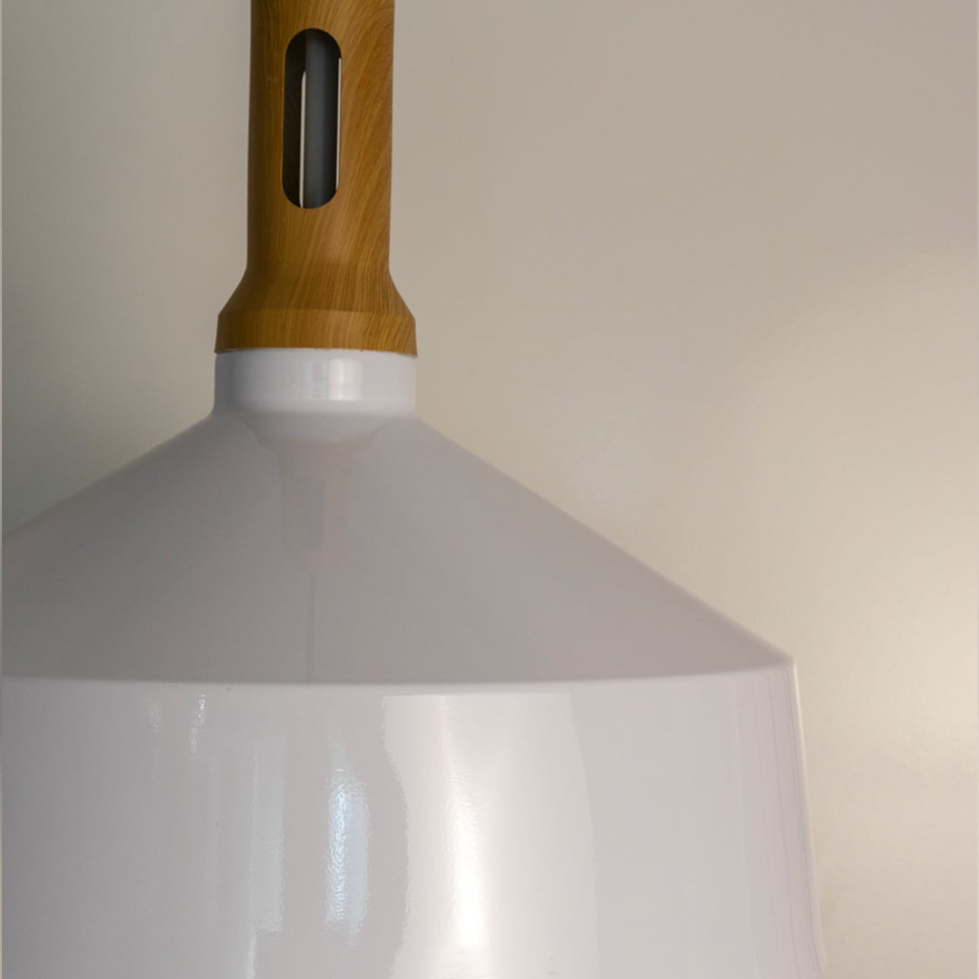 A closeup view of a white pendant light showcasing the wooden top smooth edges and clean finish revealing the fine detailing of its minimalist design.