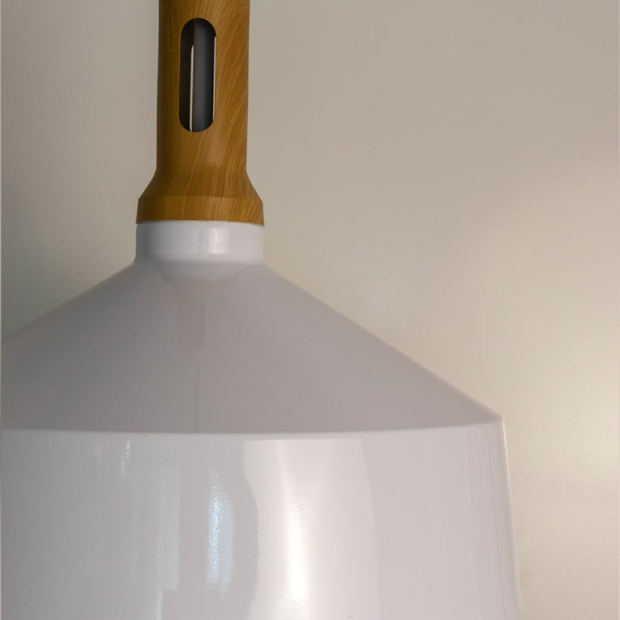 A closeup view of a white pendant light showcasing the wooden top smooth edges and clean finish revealing the fine detailing of its minimalist design.