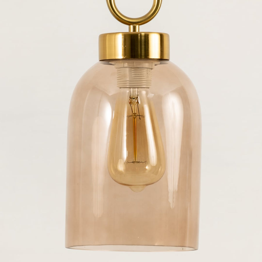 Closeup of smoked glass pendant light revealing metal frame and clear bulb design for a refined yet minimalistic lighting statement.