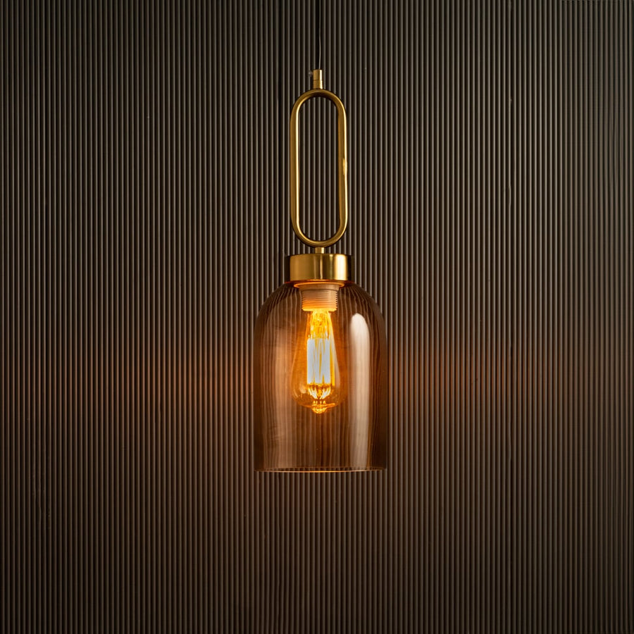 Modern amber glass pendant light with warm bulb glowing on a dark textured background showcasing elegant metal loop detail and premium lighting design with light on.