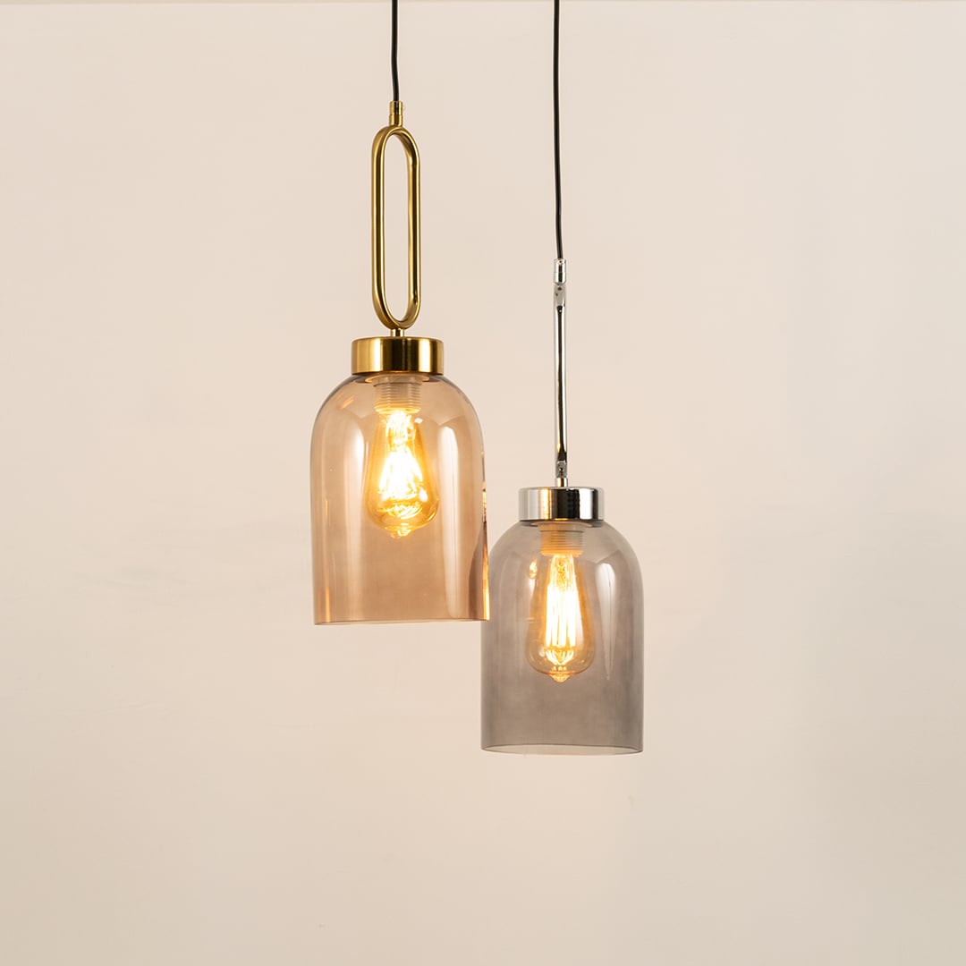 Modern dual glass pendant lights featuring amber and smoke grey shades with metal fittings ideal for living and dining spaces.