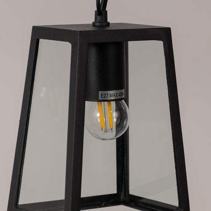 Closeup of matte black outdoor lantern showing clear glass panels and bulb detail ideal for porch or garden lighting.