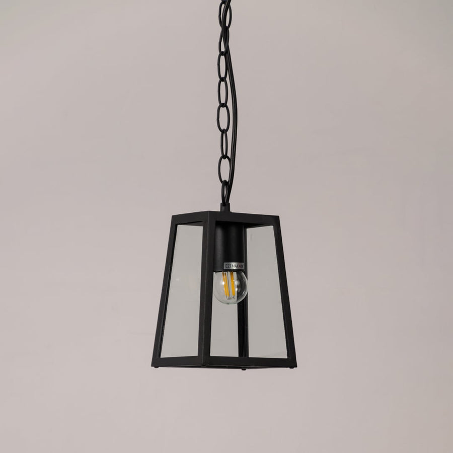 Matte black metal outdoor pendant light with clear glass body displayed on white background for modern exterior decor.