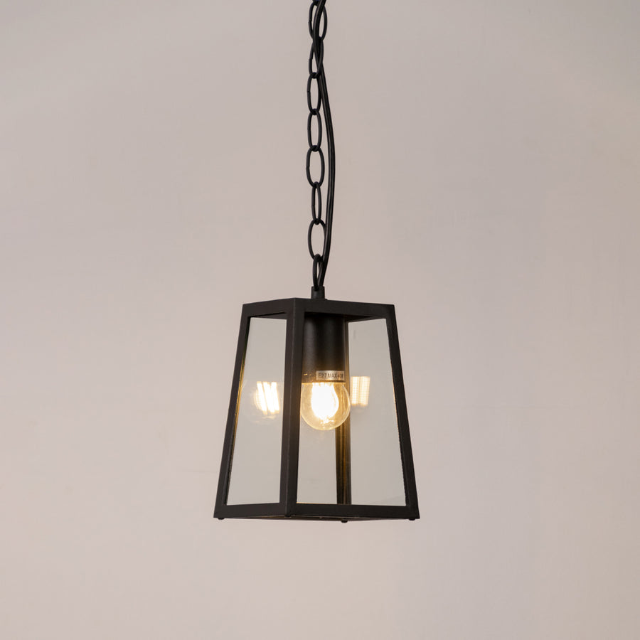 Modern outdoor pendant light in black metal with glass panels for entrance or patio decor lighting white background.