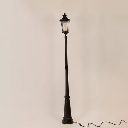 Black metal outdoor lamp post with clear glass lantern displayed on white background with light off for product detailing.
