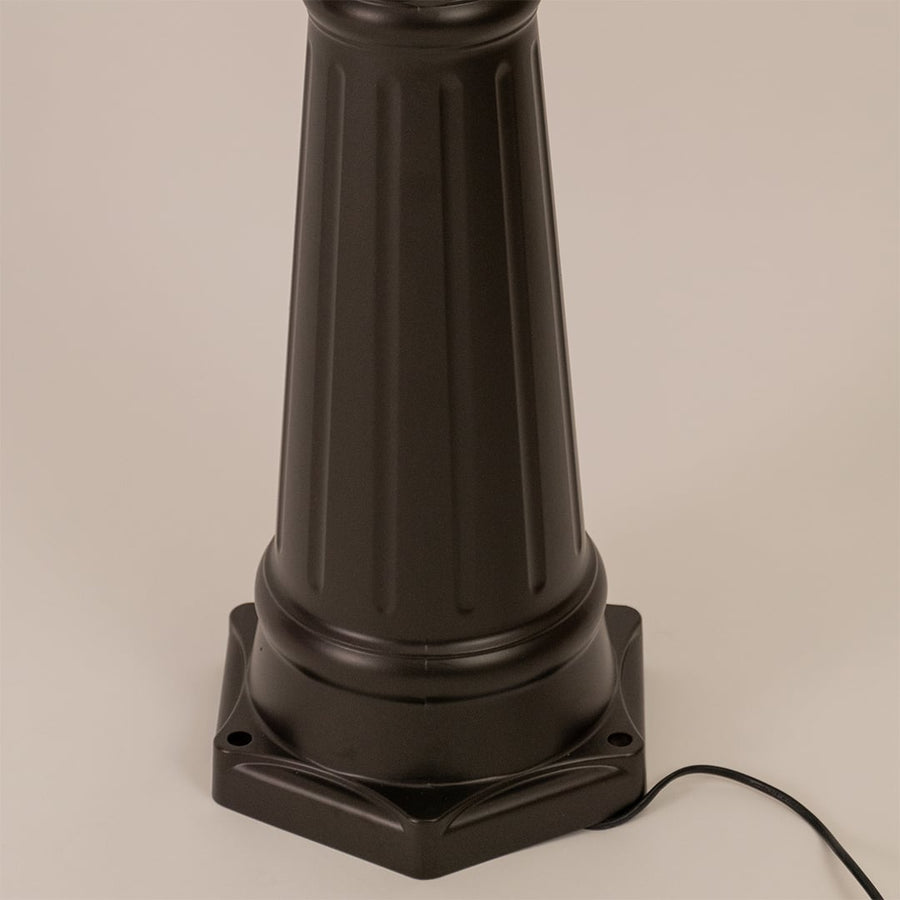 Detailed view of black metal outdoor lamp post highlighting glass lantern shape and textured pole for outdoor lighting.