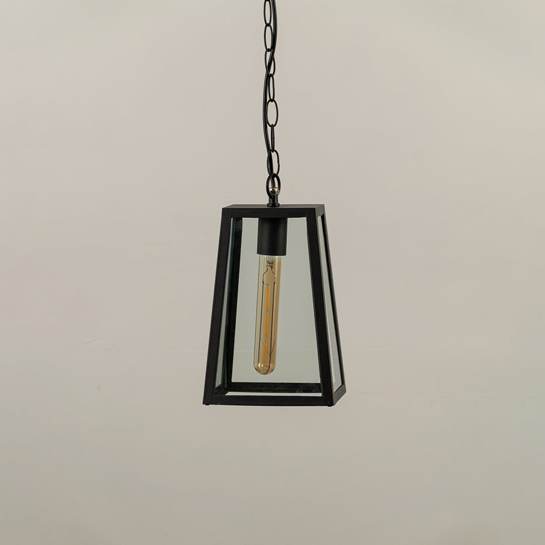 Black tapered hanging lantern on white background with light off displaying clear glass panels and minimal metal frame suitable for contemporary exterior decor.