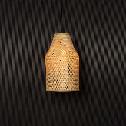 Woven bamboo pendant light glowing on black background with tall cylindrical wicker shade for bohemian interiors.