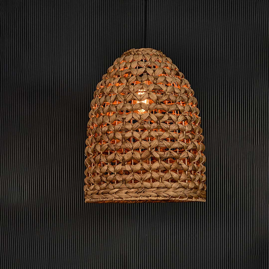 Illuminated brown rattan pendant light with woven texture creating warm glow and elegant boho appeal.