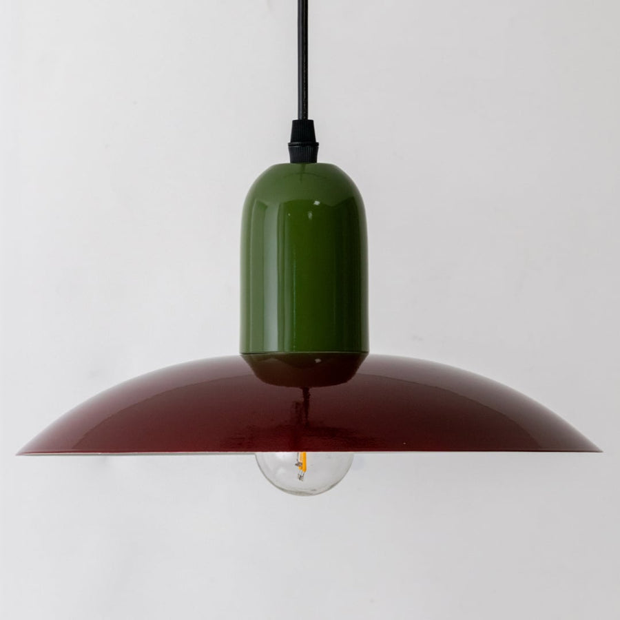 Closeup of green and burgundy metal pendant light showcasing elegant finish and modern design.
