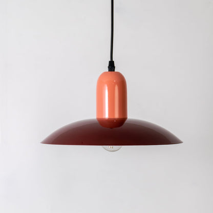 Red metal pendant light with bulb off and peach top displayed on white background for modern kitchen dining decor.