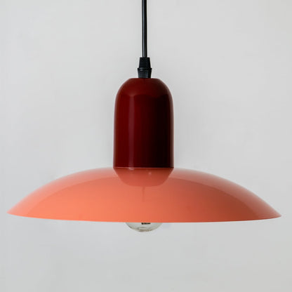 Orange metal pendant light with wide shade design for kitchen island dining room and ceiling decor.
