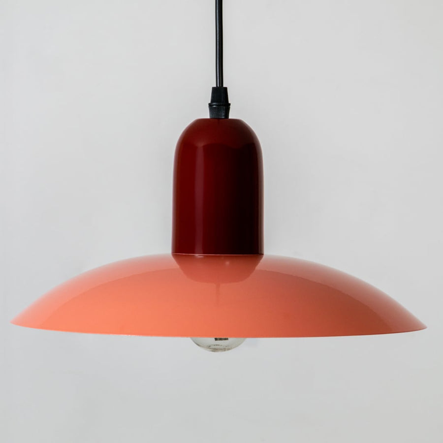 Orange metal pendant light with wide shade design for kitchen island dining room and ceiling decor.