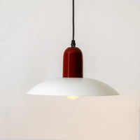 White metal pendant light with red accent and warm illumination for dining room decor.