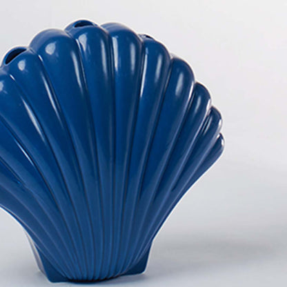 Close view of a blue shell shaped ceramic vase showing its smooth glossy surface and detailed sculpted ridges for decor styling.