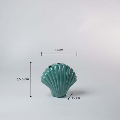 Teal ceramic shell shaped vase shown with dimensions 18 cm width 15.5 cm height and 10 cm depth giving a clear idea of its compact size.
