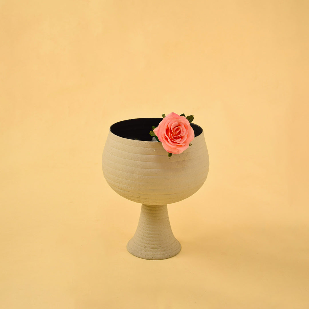 Elegant ribbed beige metal pedestal vase with flower for luxury home decor and sophisticated tabletop centerpiece style.