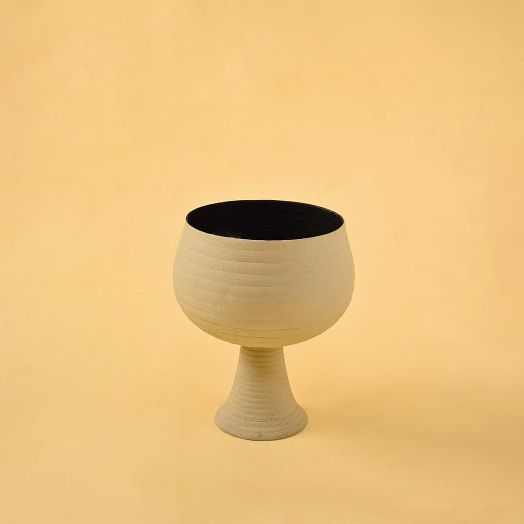 Cream metal pedestal bowl decor on a clean white background showcasing its modern textured finish for versatile placement.