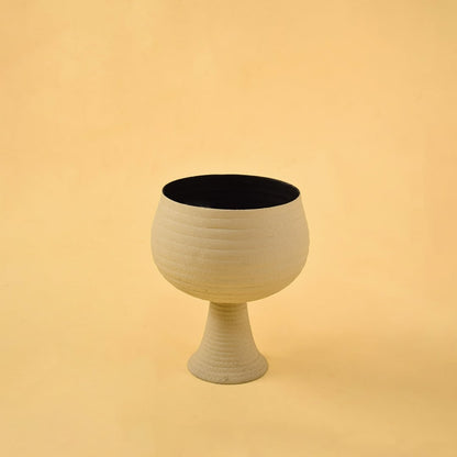 Cream metal pedestal bowl decor on a clean white background showcasing its modern textured finish for versatile placement.