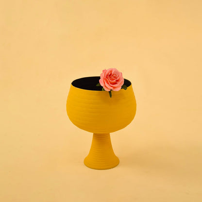 Yellow metal pedestal bowl decor styled in a warm modern space adding a bold accent to living room tables and shelves.
