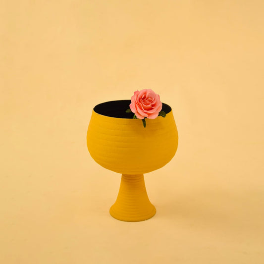 Yellow metal pedestal bowl decor styled in a warm modern space adding a bold accent to living room tables and shelves.