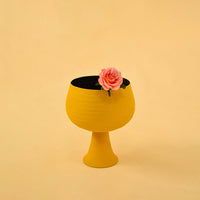 Yellow metal pedestal bowl decor styled in a warm modern space adding a bold accent to living room tables and shelves.