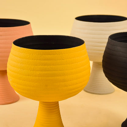 Detailed view of ribbed texture on colorful metal pedestal vases for artistic modern home decor and interior design accents.