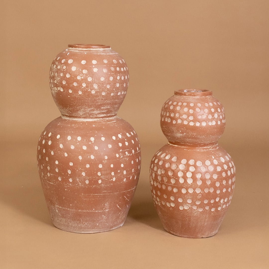 Brown terracotta polka dot decorative vase displayed with matching earthy decor items creating a coordinated grouped setup for interiors.
