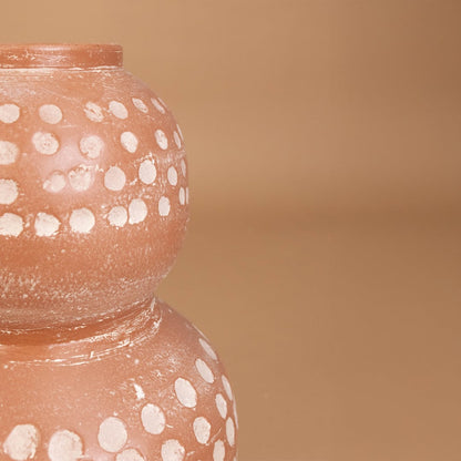 Closeup of brown terracotta decorative vase with white polka dots showing detailed handcrafted texture ideal for modern artistic home decor.