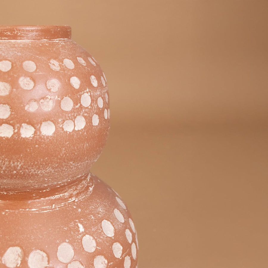Closeup of brown terracotta decorative vase with white polka dots showing detailed handcrafted texture ideal for modern artistic home decor.