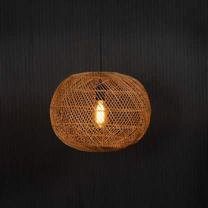Round rattan pendant light glowing warmly on black background showcasing ambient light through woven shade.
