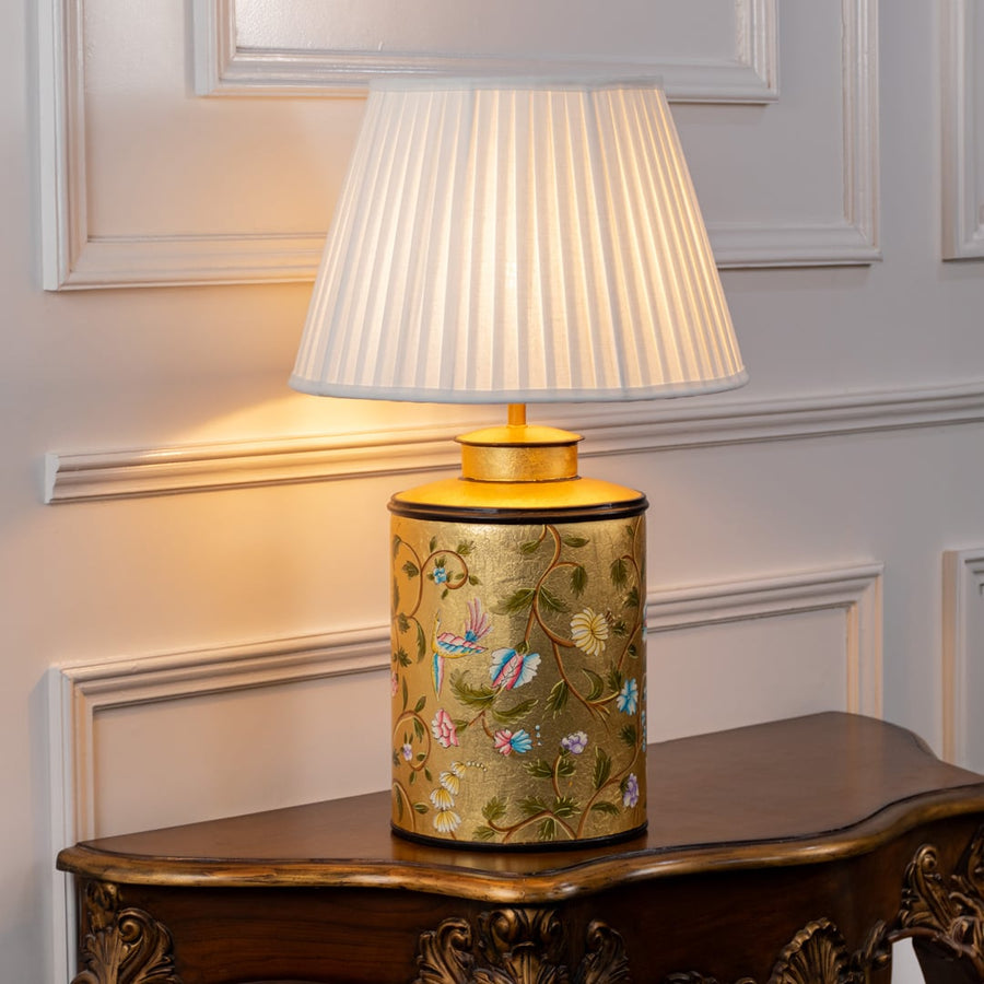 Table lamp with a yellow decorative ceramic base and pleated fabric lampshade shown on a white background.