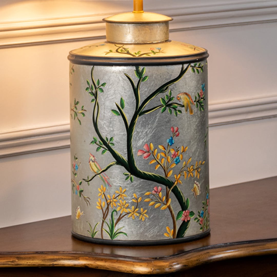 Table lamp closeup highlighting hand painted floral bird artwork on ceramic base with smooth glazed finish and gold detailing.