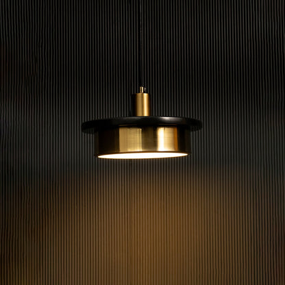 Black and gold metal pendant light illuminated warmly adding contemporary elegance to modern dining spaces.