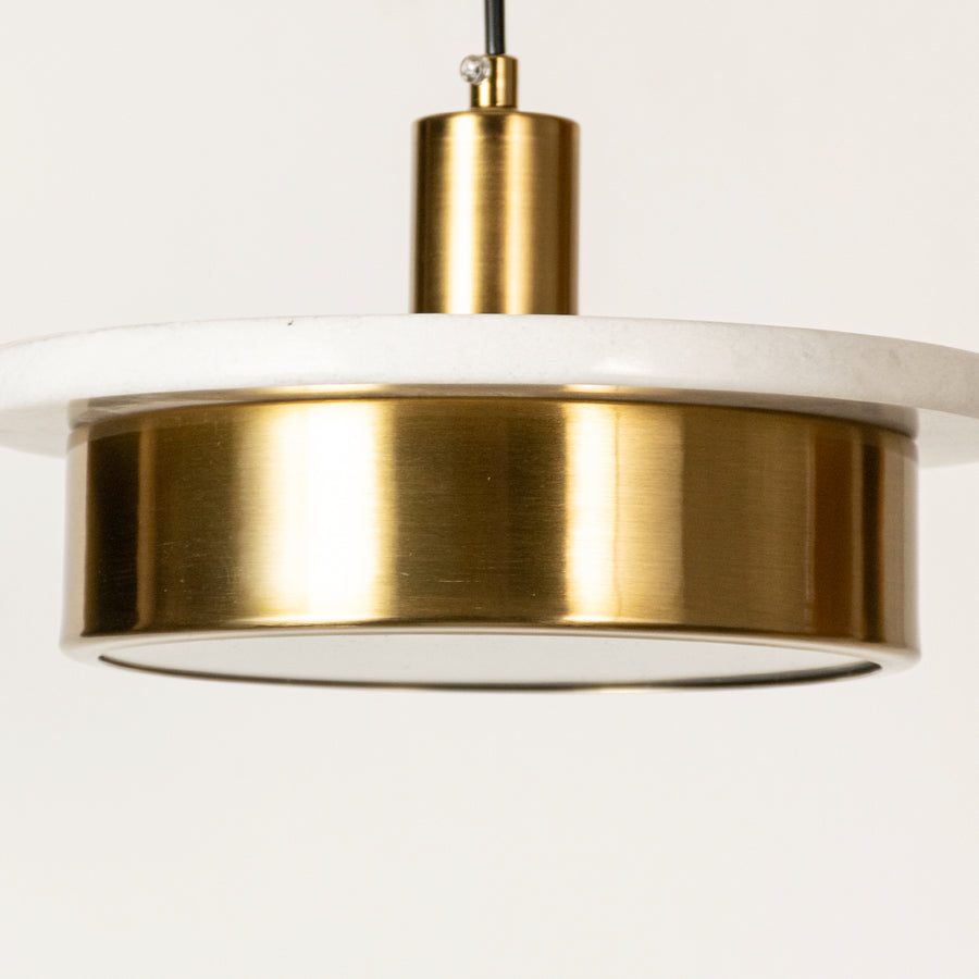 Gold metal pendant light closeup featuring sleek circular design and luxury modern lighting craftsmanship details.