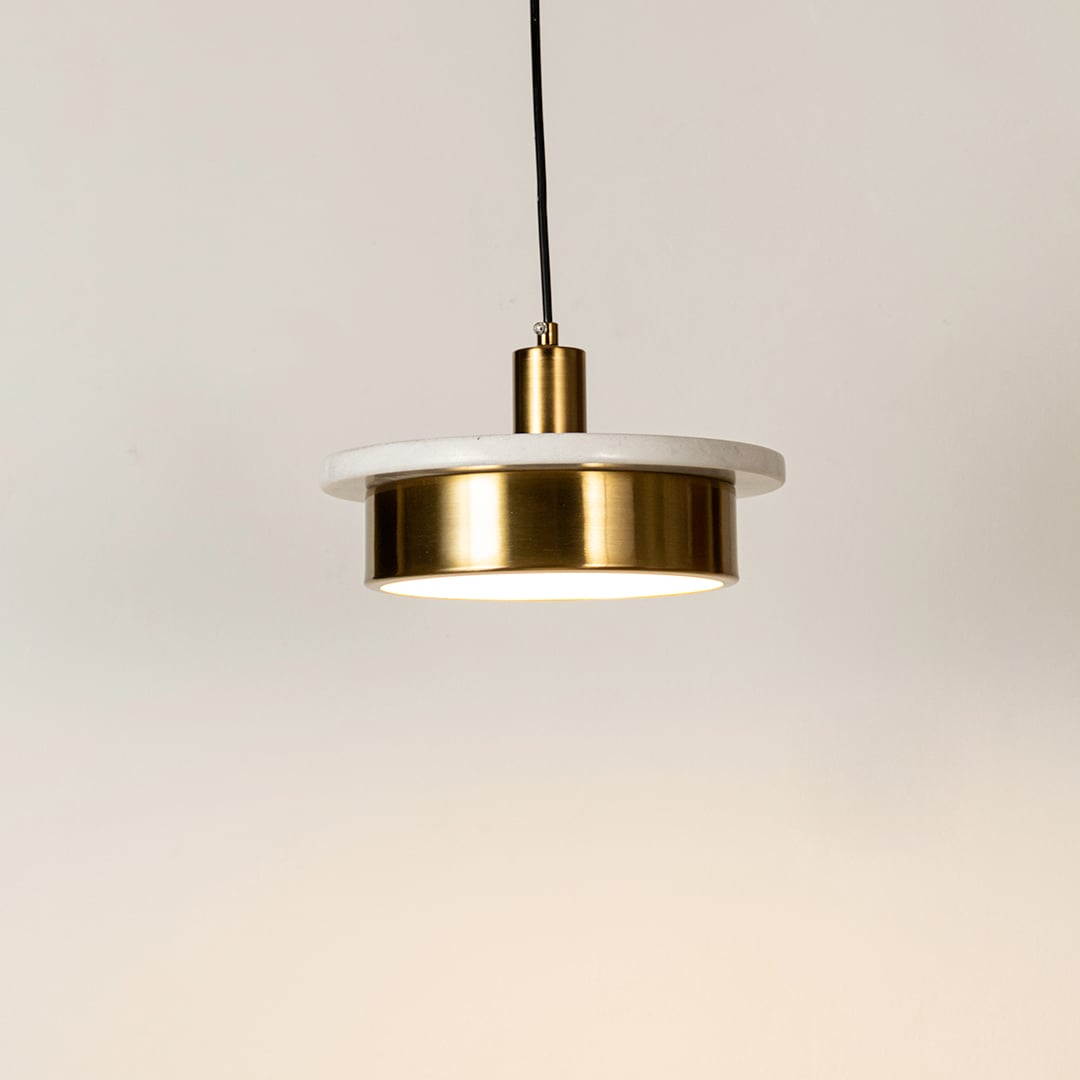 Gold metal pendant light with frosted diffuser glowing softly to enhance modern decorative ceiling lighting appeal.