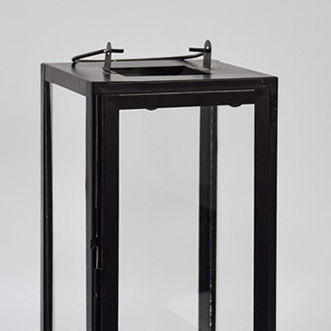 Closeup of minimal black metal lantern frame with clear glass panels for elegant decor styling use.
