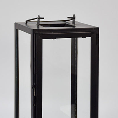Closeup of minimal black metal lantern frame with clear glass panels for elegant decor styling use.