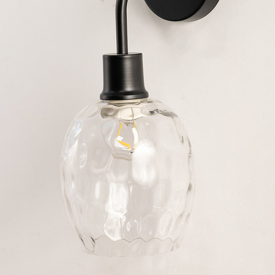 Modern black metal wall light with textured glass shade for stylish bedroom hallway and living room decor.