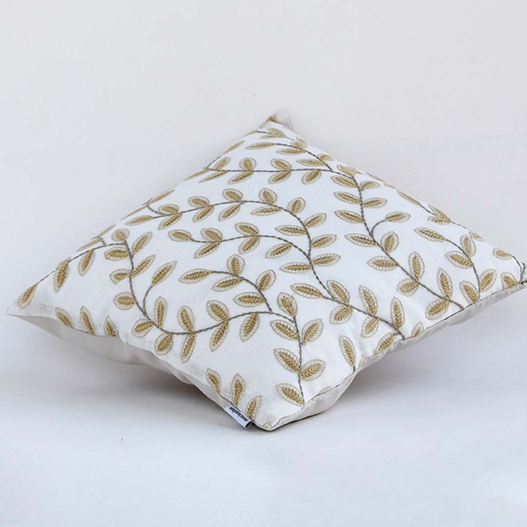 Soft cotton cushion cover with golden botanical design shown in an angled view offering a nature inspired décor accent with a gentle breathable and skin friendly fabric.