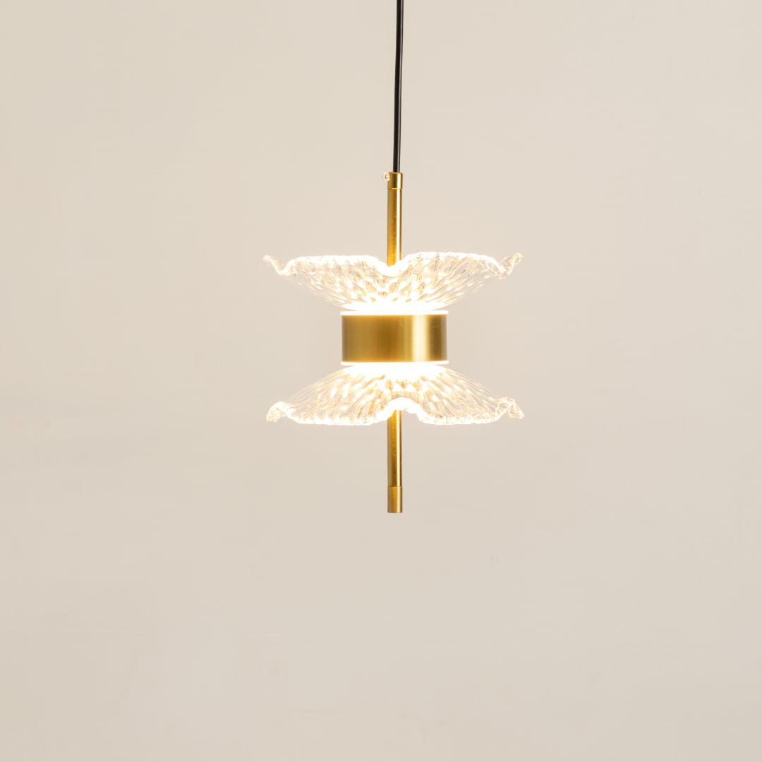 Gold pendant light with double textured glass shades glowing softly on a clean white background for modern home lighting decor.