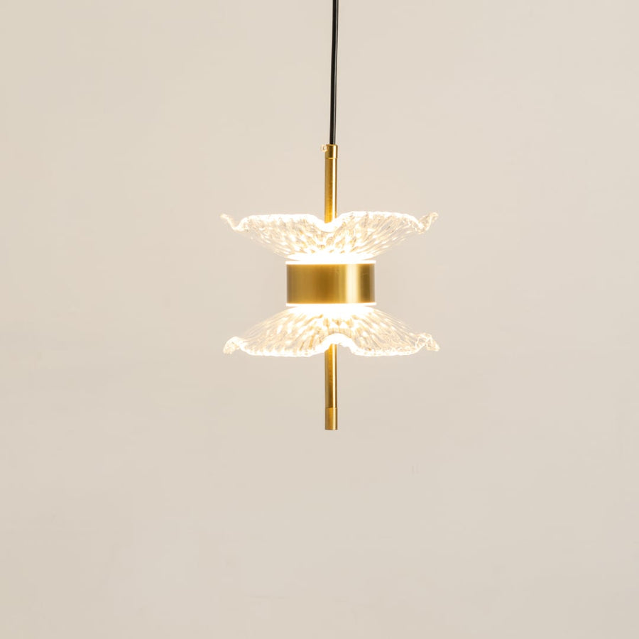 Gold pendant light with double textured glass shades glowing softly on a clean white background for modern home lighting decor.