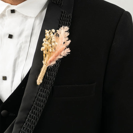 Elegant boutonniere on black background featuring dried flowers rustic groom lapel pin wedding decor.