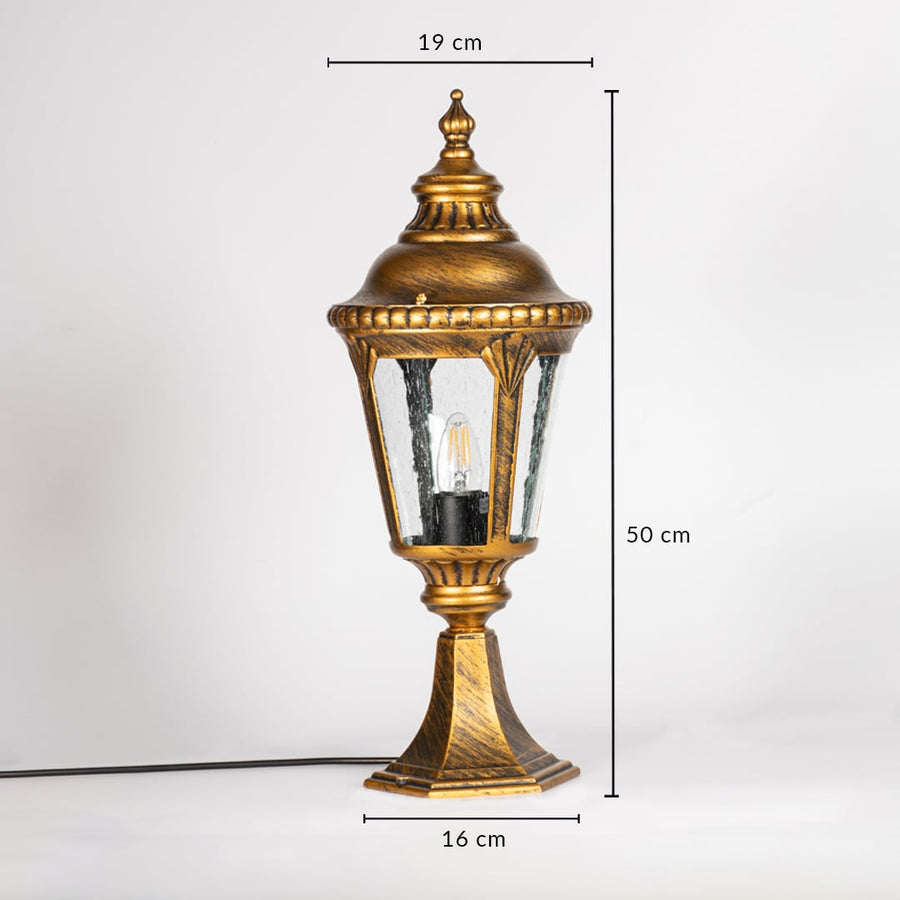 Golden pillar lamp with clear glass shown with dimensions height 50cm width 19cm base 16cm for outdoor gate and garden decor.