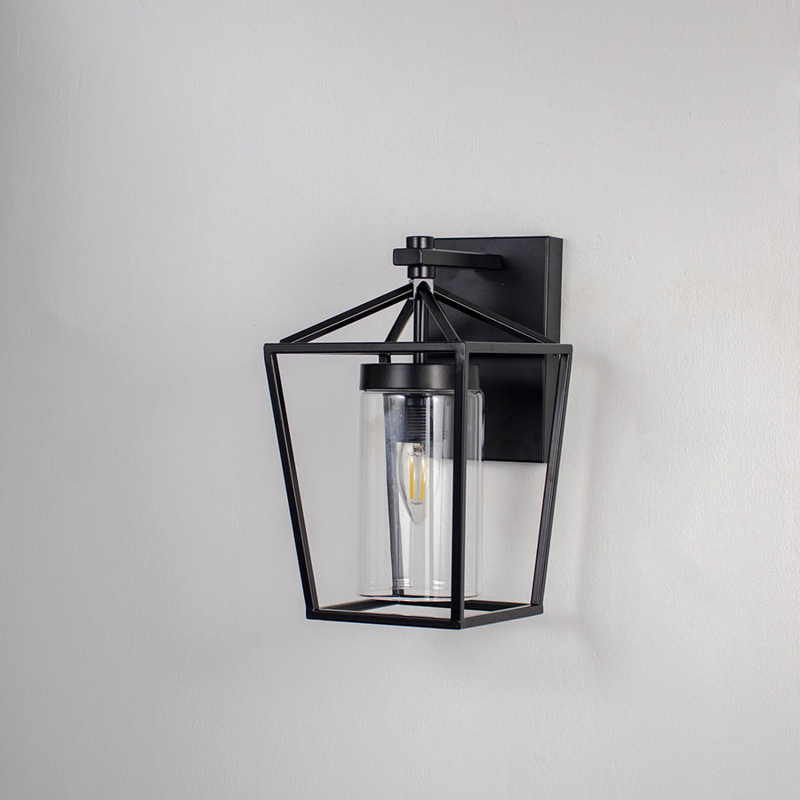 Black metal outdoor wall light on white background with clear glass shade for elegant exterior wall decor.