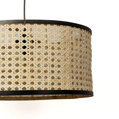Detailed view of woven rattan drum shade with black trim highlighting artisan craftsmanship.